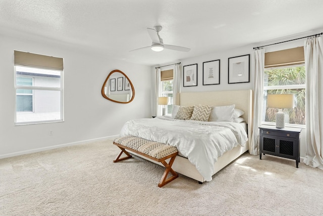 carpeted bedroom featuring baseboards, a textured ceiling, and ceiling fan