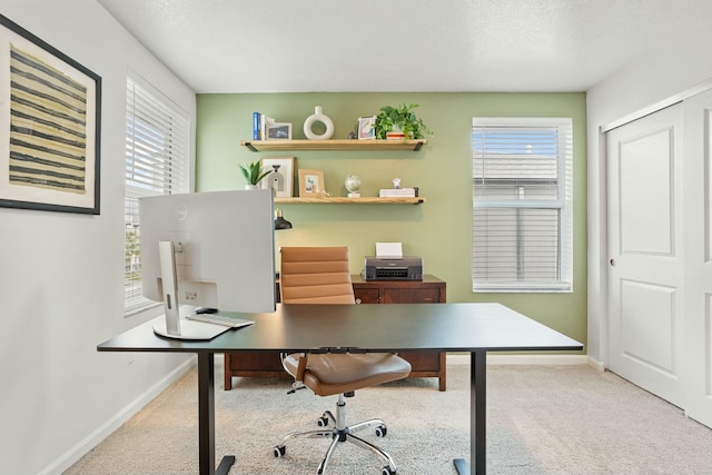 carpeted home office featuring baseboards