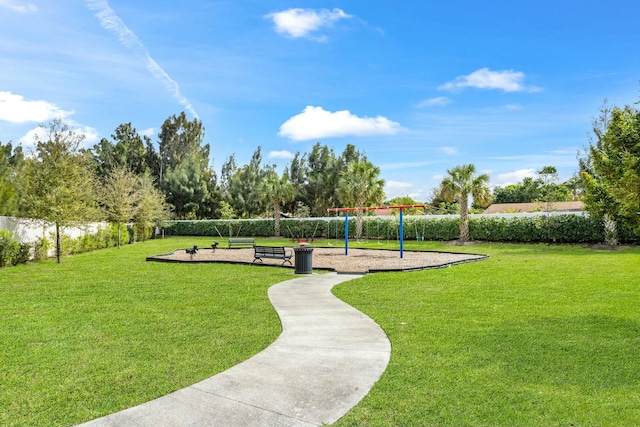 view of property's community featuring playground community and a yard