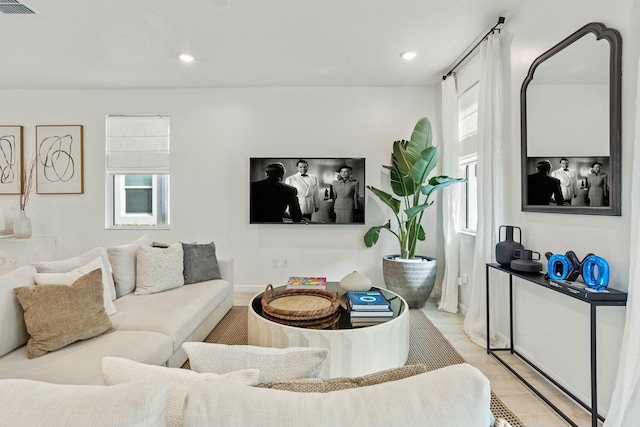 living room with recessed lighting, visible vents, and light wood-style flooring