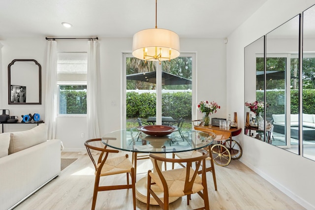 dining space with baseboards and light wood finished floors