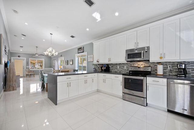 kitchen with appliances with stainless steel finishes, dark countertops, visible vents, and decorative backsplash