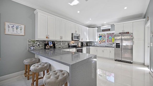 kitchen with light tile patterned floors, appliances with stainless steel finishes, ornamental molding, a peninsula, and backsplash