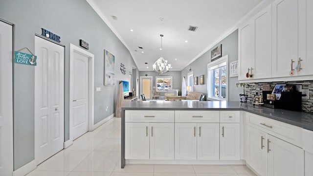 kitchen featuring a notable chandelier, dark countertops, visible vents, backsplash, and light tile patterned flooring