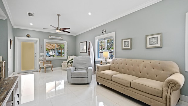 living room with a wealth of natural light, visible vents, crown molding, and baseboards