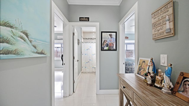 hallway featuring a wealth of natural light, baseboards, crown molding, and light tile patterned flooring