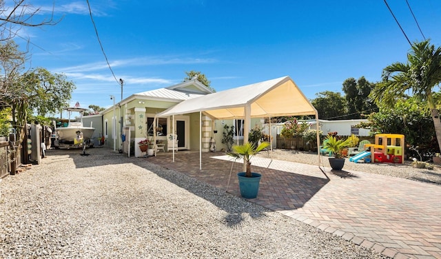 back of house with a patio area, a fenced backyard, and a playground