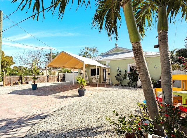 exterior space with a patio, fence, and stucco siding