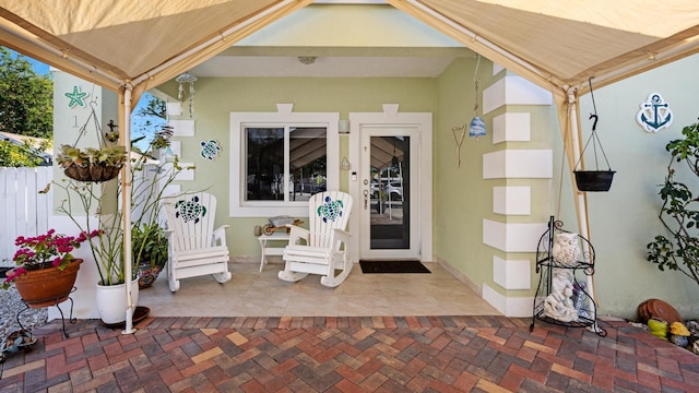 entrance to property featuring a patio and stucco siding