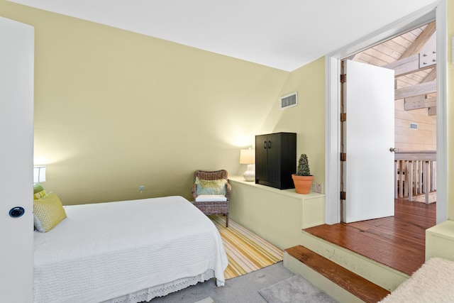 bedroom featuring lofted ceiling and visible vents