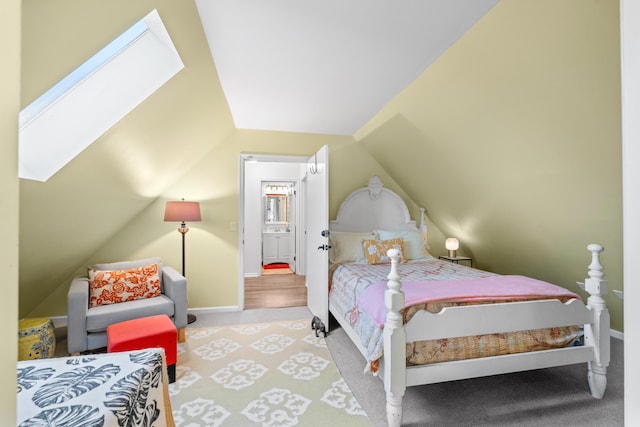 bedroom with lofted ceiling with skylight, carpet, and baseboards