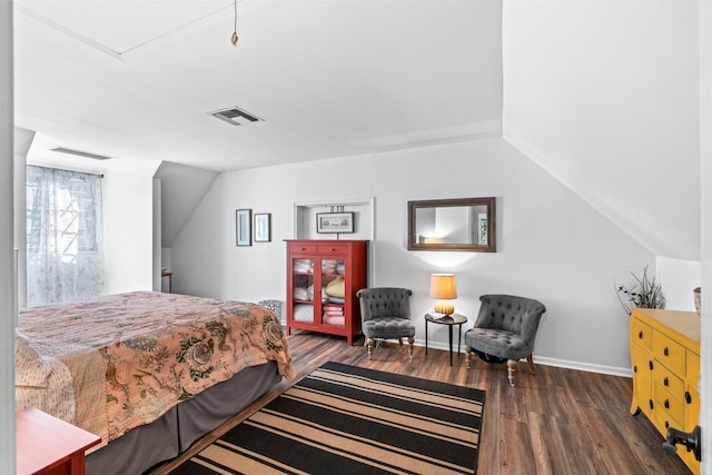 bedroom with lofted ceiling, visible vents, baseboards, and wood finished floors