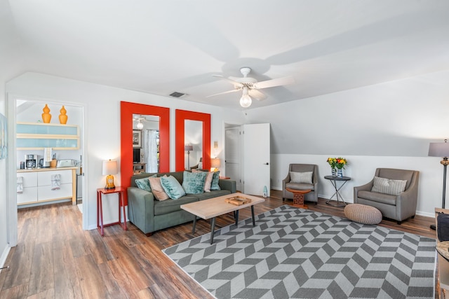 living area featuring lofted ceiling, ceiling fan, baseboards, and wood finished floors