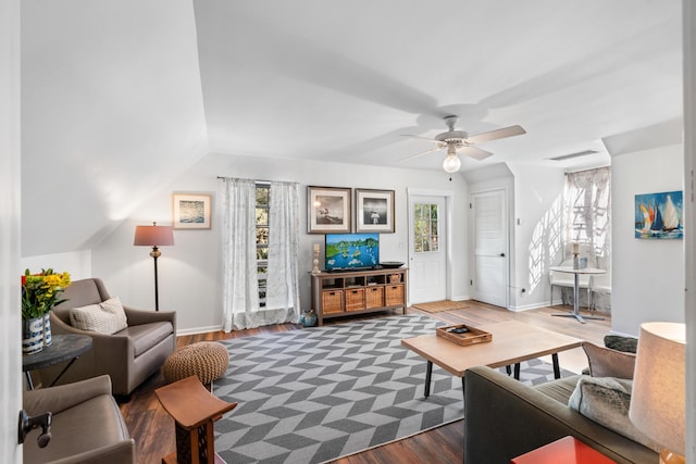 living area with dark wood-style floors, ceiling fan, visible vents, and a healthy amount of sunlight