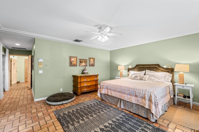 bedroom with brick floor, visible vents, baseboards, and crown molding