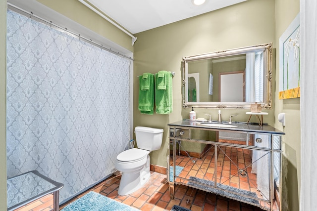 bathroom with curtained shower, baseboards, vanity, and toilet