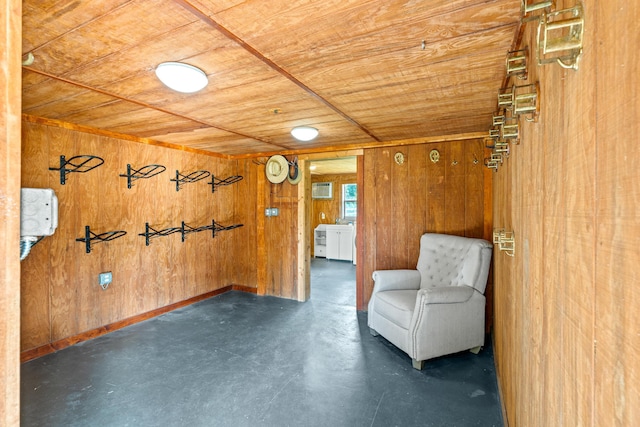 unfurnished room featuring wooden ceiling, concrete floors, baseboards, and wood walls