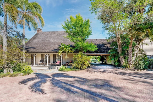 view of front of home with decorative driveway and a chimney