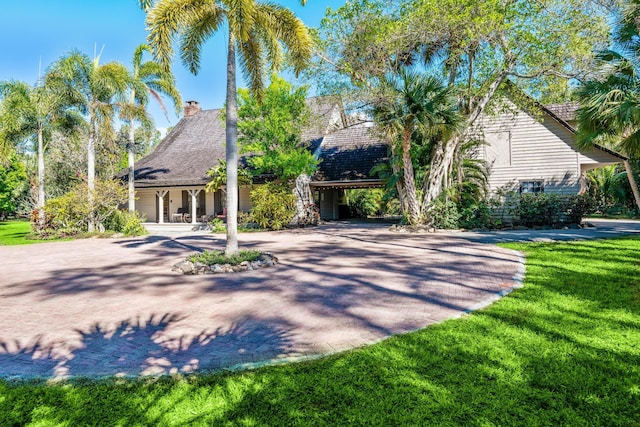 view of front of home with driveway and a front lawn