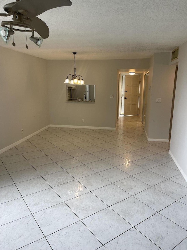 unfurnished room with light tile patterned floors, visible vents, a textured ceiling, and ceiling fan with notable chandelier