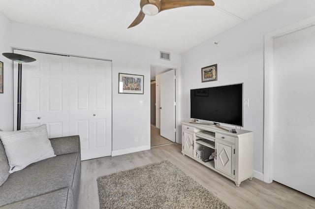 living area with light wood-style flooring, visible vents, ceiling fan, and baseboards