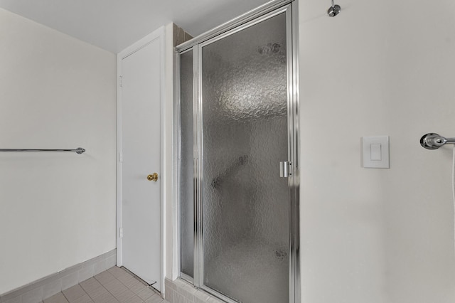 bathroom featuring a stall shower, baseboards, and tile patterned floors