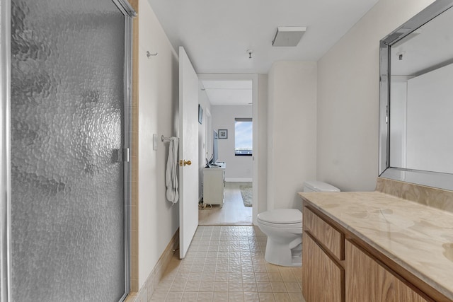 bathroom featuring a stall shower, vanity, toilet, and baseboards