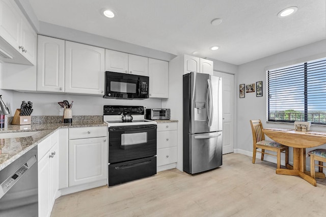 kitchen with white cabinets, light stone counters, black appliances, a sink, and recessed lighting