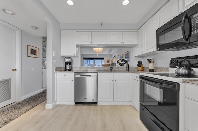 kitchen featuring black appliances, light wood-style flooring, and white cabinetry