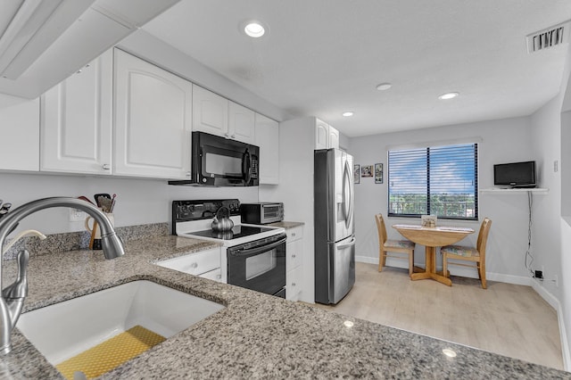 kitchen with visible vents, electric range, a sink, black microwave, and stainless steel fridge with ice dispenser