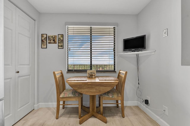 dining space featuring baseboards and wood finished floors