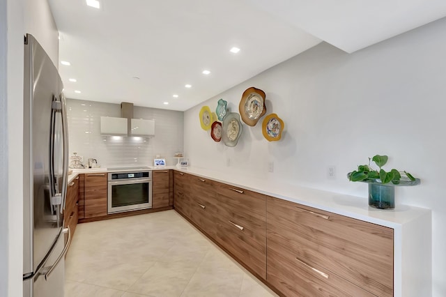 kitchen featuring recessed lighting, light countertops, appliances with stainless steel finishes, modern cabinets, and brown cabinets