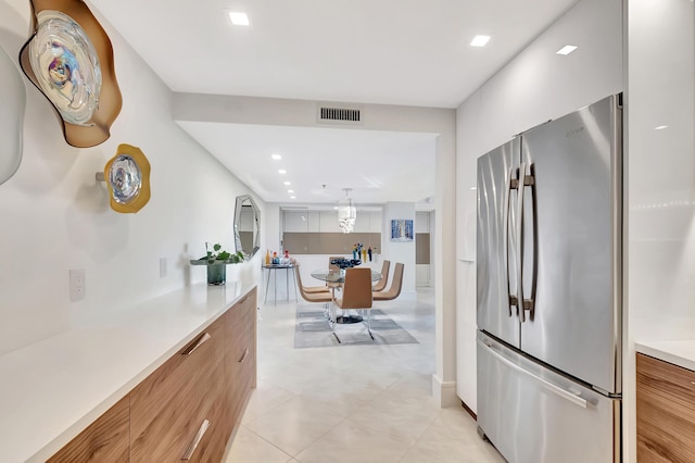 kitchen featuring visible vents, light countertops, recessed lighting, freestanding refrigerator, and modern cabinets