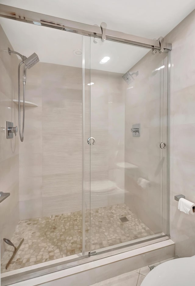 bathroom with a shower stall and toilet