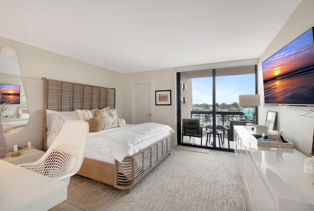 bedroom featuring access to exterior and a wall of windows