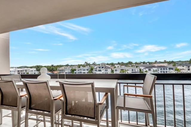 balcony featuring a residential view and a water view