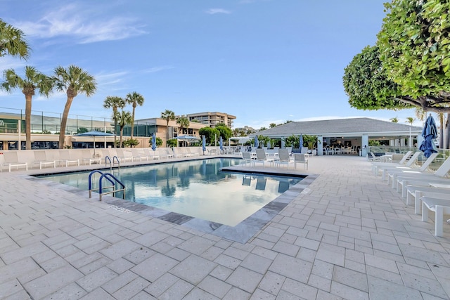 pool with a patio and fence