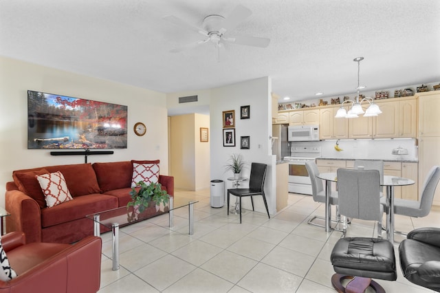 living area with ceiling fan with notable chandelier, visible vents, a textured ceiling, and light tile patterned flooring