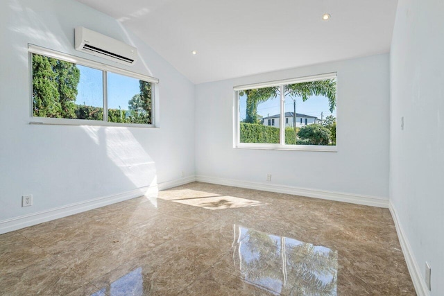 empty room featuring a wall unit AC, marble finish floor, baseboards, and vaulted ceiling