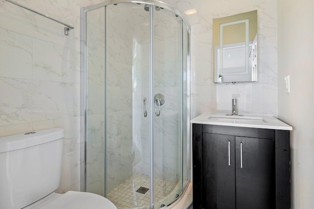 bathroom featuring toilet, a marble finish shower, and tile walls