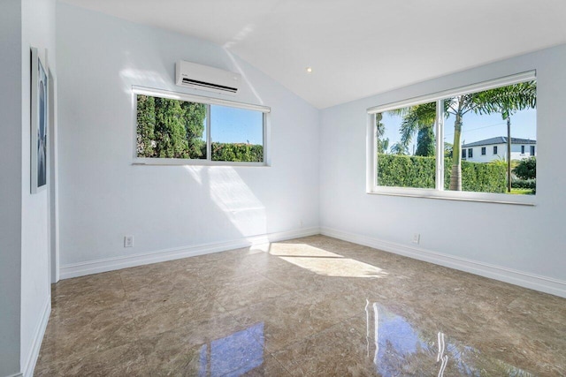 spare room with lofted ceiling, an AC wall unit, and baseboards