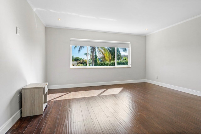 unfurnished room with baseboards, dark wood finished floors, and crown molding