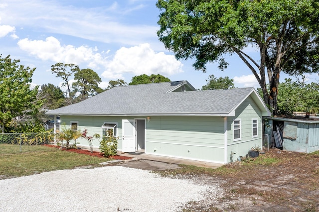 single story home with roof with shingles and fence