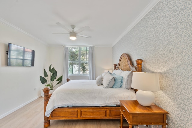 bedroom featuring light wood finished floors, ornamental molding, a ceiling fan, baseboards, and wallpapered walls