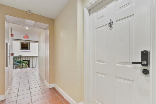 hallway with light tile patterned floors and baseboards