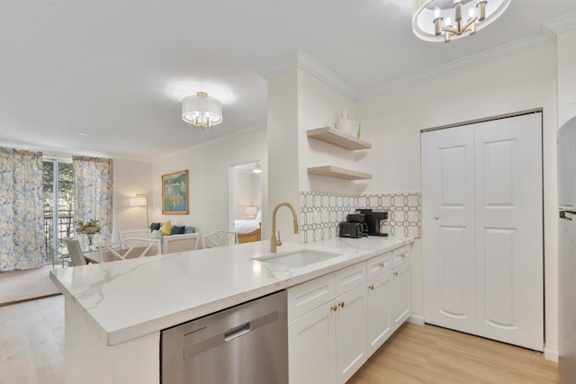 kitchen featuring a notable chandelier, a sink, a peninsula, and stainless steel dishwasher