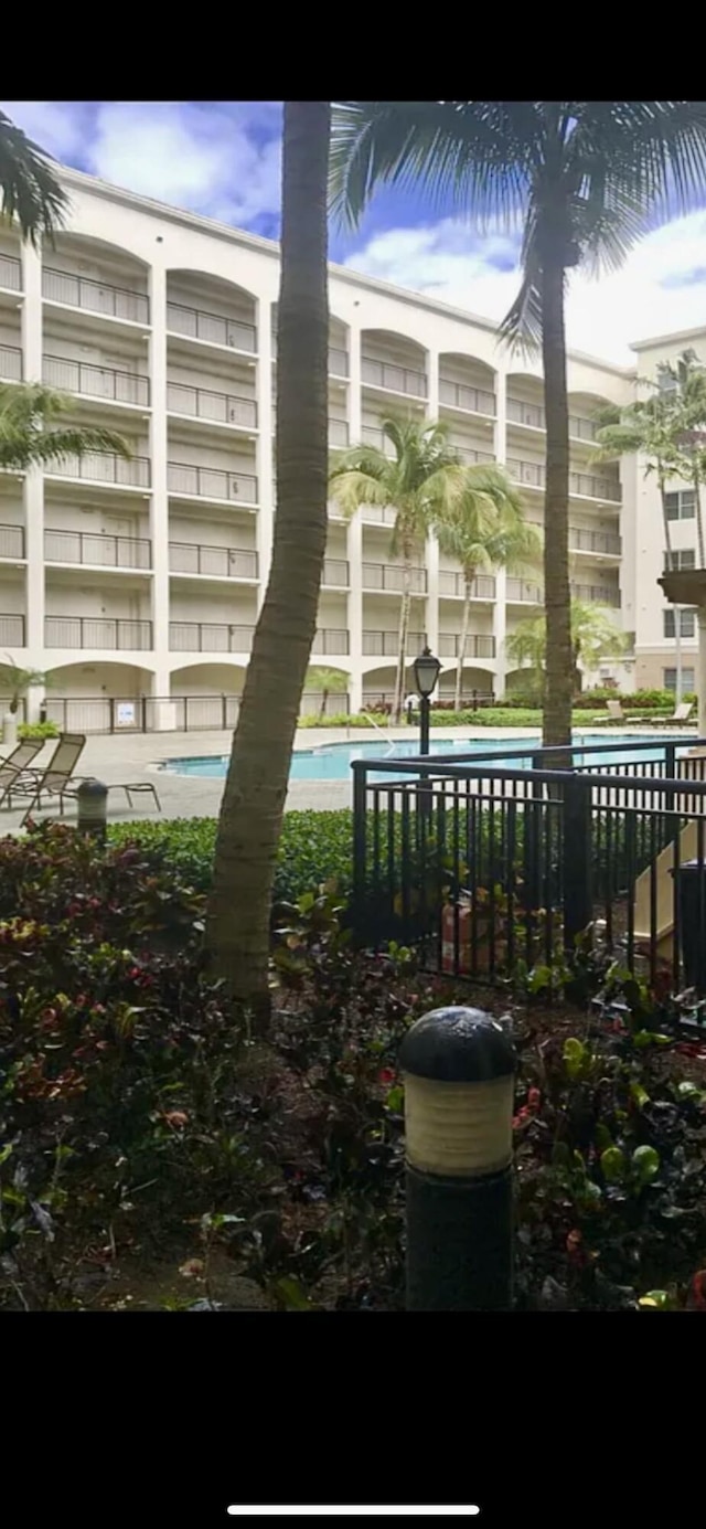 view of property's community with fence and a pool