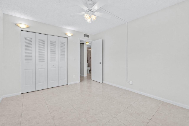 unfurnished bedroom with a closet, visible vents, a textured ceiling, and baseboards