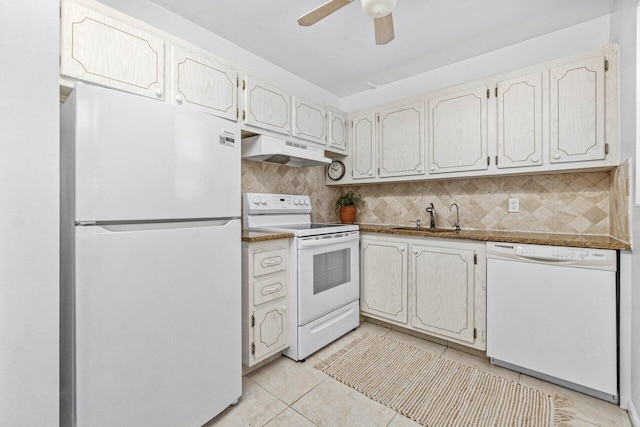 kitchen featuring white appliances, a sink, under cabinet range hood, and decorative backsplash