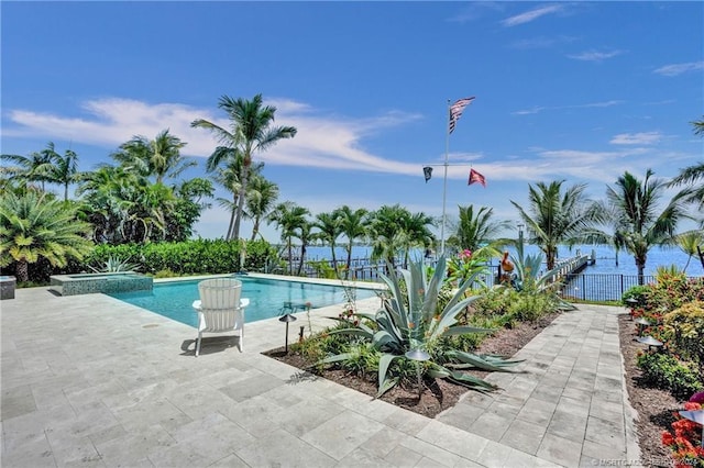 view of swimming pool featuring a pool with connected hot tub, a patio area, and fence